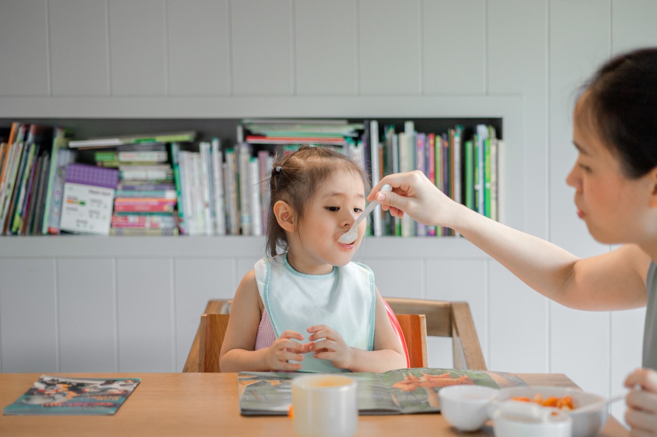 child being fed at table